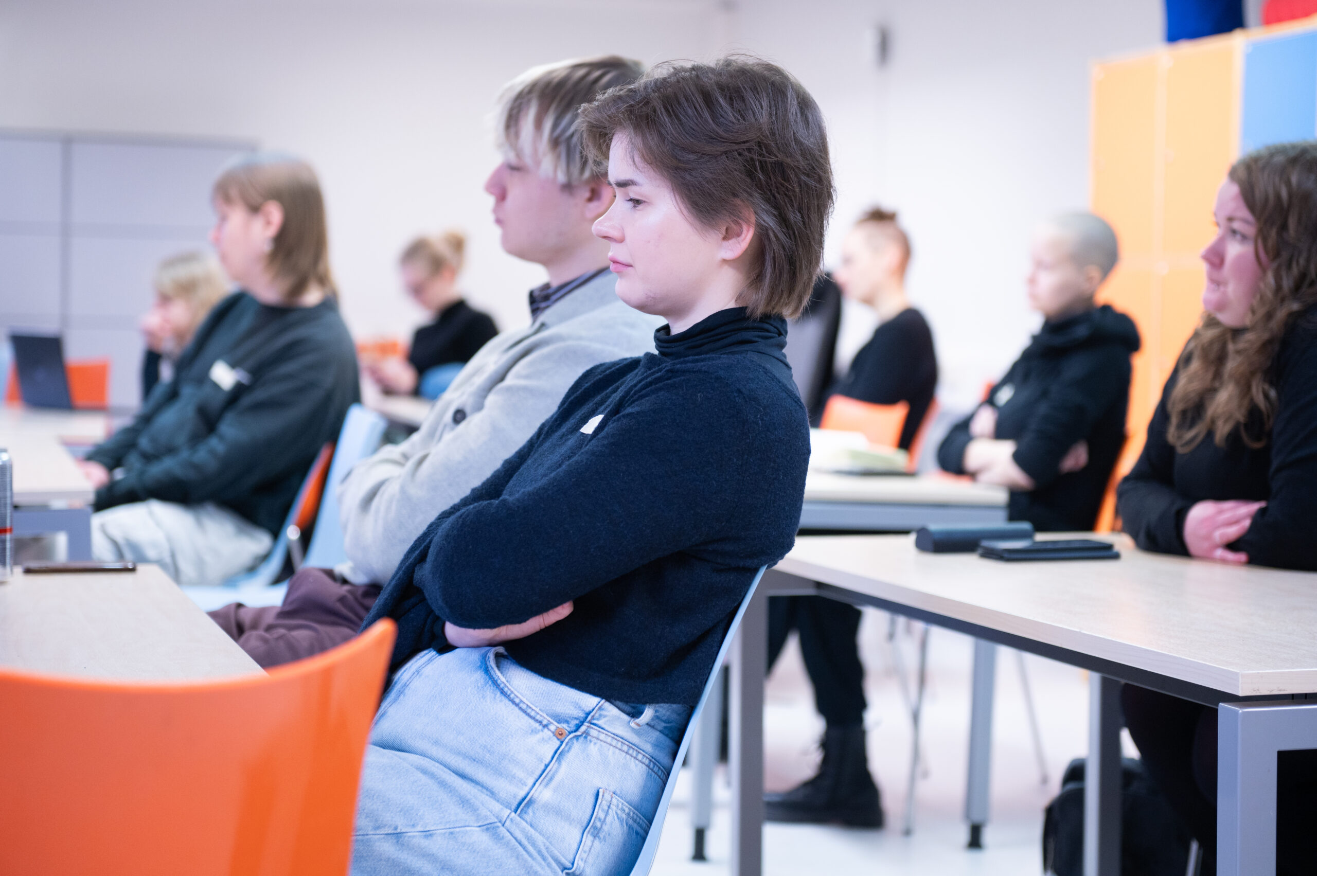 Tapahtuman osallistujia istumassa riveissä ja seuraamassa keskustelua.