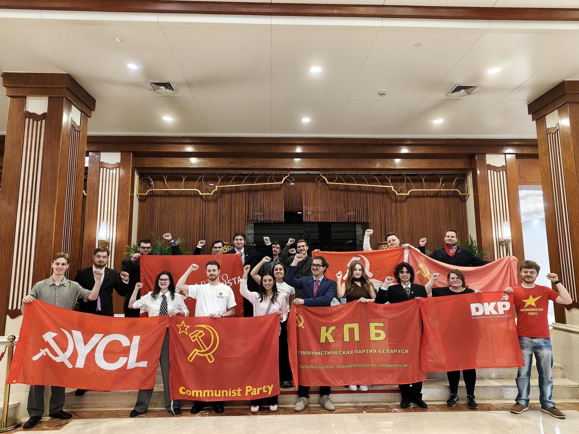 Yhteiskuva nuorista kommunisteista järjestöjensä lippujen kanssa Kiinan opintomatkalla.