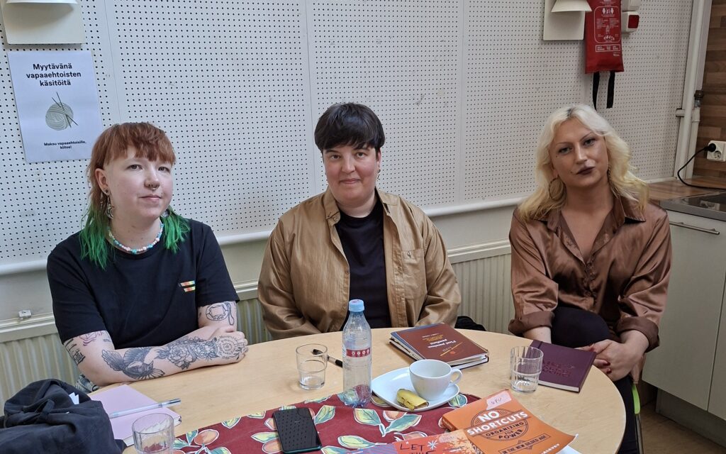 Tilaisuuden panelistit istuvat pöydän takana.